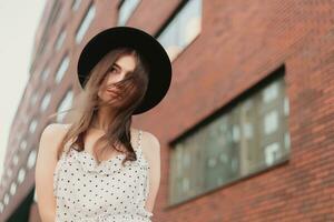 A young teenage girl in a white dress and hat photo