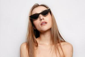 Close up shot of stylish young woman in sunglasses smiling photo