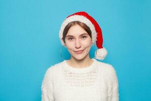 pretty blond wearing christmas hat on light blue background photo