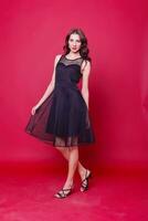 Beautiful young woman in elegant black cocktail dress photo