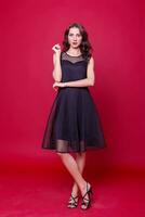 Beautiful young woman in elegant black cocktail dress photo