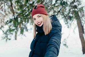 invierno mujer soplo nieve en un parque foto