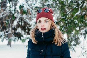 invierno mujer soplo nieve en un parque foto