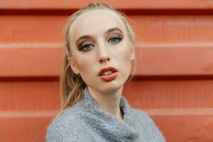 Model pointing upwards in studio and looking at camera photo