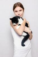 Beautiful smiling woman with a kitten in her arms, studio picture, close-up photo