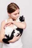 Beautiful smiling woman with a kitten in her arms, studio picture, close-up photo