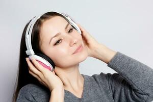 contento mujer o Adolescente niña en auriculares escuchando a música foto