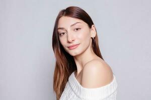 Beautiful woman face close up portrait young studio on gray photo