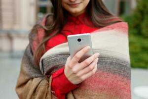 hermosa mujer utilizando inteligente teléfono tecnología aplicación en ciudad calles foto