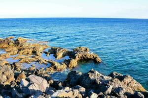 el rocoso línea costera de el Oceano foto