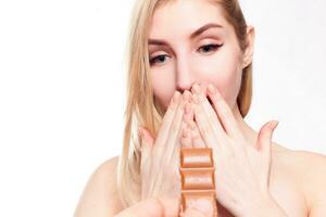 Lovely smiling teenage girl eating chocolate photo