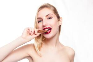 Lovely smiling teenage girl eating chocolate photo