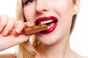 Lovely smiling teenage girl eating chocolate photo