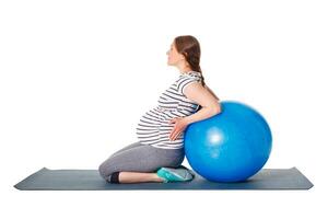 Pregnant woman doing exercises with exercise ball photo