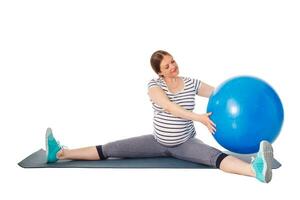 Pregnant woman doing exercises with exercise ball photo