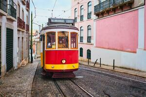 Famous vintage yellow tram 28 in the narrow streets of Alfama district in Lisbon, Portugal photo