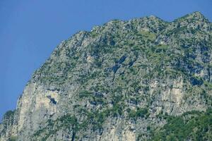 un montaña con un grande rock cara y arboles foto