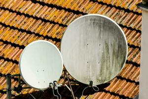 two satellite dishes on a roof photo