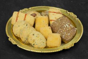 dulce y sabroso mezclado galletas o galletas servido en dorado plato foto