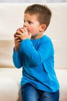 Cute little boy is eating apple. photo