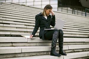 Businesswoman having a headache while working outdoor. photo