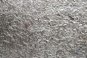 Silver wrinkled food foil background texture, crumpled aluminum foil, abstract shiny background photo