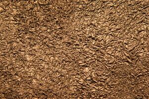 Texture of crumpled bronze foil. Metallic background photo