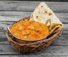 Indian Delicious Cuisine Paneer Tikka Masala With Tandoori Chapati on Wooden Background photo