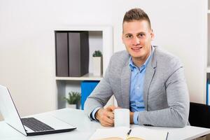 Businessman is drinking coffee at his office. photo