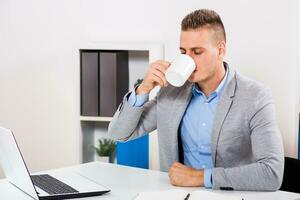 empresario es Bebiendo café a su oficina. foto