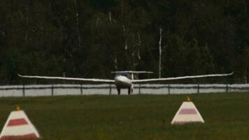 planeador es aterrizaje en un pequeño aeródromo. no motorizado aeronave. planeador en contra verde bosque video