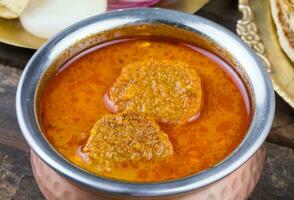 Indian Traditional Cuisine Gatta Curry on Wooden Background photo