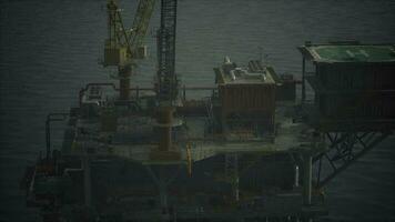 An oil rig standing tall in the middle of the vast ocean video