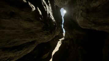 un estrecho paso en un cueva con luz de sol viniendo mediante video