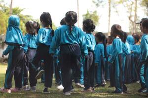 Magelang,Indonesia.12-05-2023.group of kindergarten school children and teachers playing and learning outdoors. photo