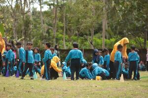 Magelang,Indonesia.12-05-2023.group of kindergarten school children and teachers playing and learning outdoors. photo