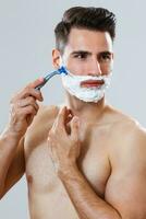 Handsome man shaving his beard photo