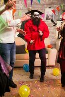 Excited man dressed up like a pirate at halloween party with his friends. photo