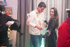 Zombie and beautiful witch home having fun at halloween party. photo