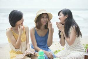 mas joven asiático mujer amigo relajante hablando con felicidad emoción a vacaciones mar playa foto