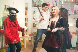 Shy blond woman dressed up like a vampire at halloween party. photo
