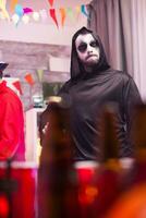 Scary man dressed up like a grim reaper at halloween celebration. photo