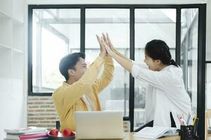 Motivated multinational team raise high fives on briefing after finding problem solution as successful brainstorm result. photo