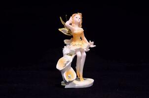 a white and yellow fairy figurine with wings photo