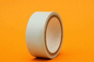 a roll of white tape on an orange background photo