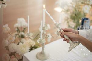 Close up of Bride and groom holding wedding candle during engagement ceremony photo