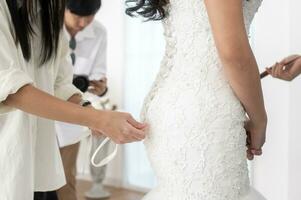 Close up of tying bow on elegant White bridal wedding dress photo