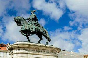 a statue of a man on a horse in front of a building photo