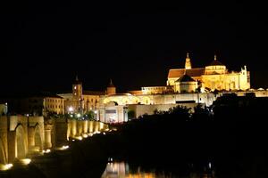 the roman bridge and the mezquina on a magina night in cordoba photo