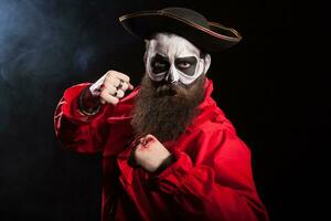 Scary pirate with fists up isolated over black background.Spooky man. photo